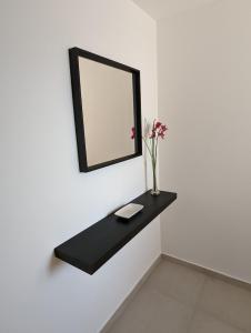 a mirror and a vase with flowers on a wall at Appartement Villa Belle Epoque Roquebrune Cap Martin in Roquebrune-Cap-Martin +8 photos