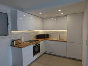 a white kitchen with white cabinets and a sink at Appartement Villa Belle Epoque Roquebrune Cap Martin in Roquebrune-Cap-Martin