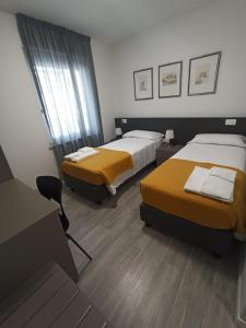 une chambre d'hôtel avec deux lits et une chaise dans l'établissement B&B Il Soffione, à Fonzaso