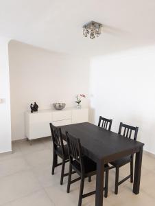 a dining room with a black table and chairs at Appartement Villa Belle Epoque Roquebrune Cap Martin in Roquebrune-Cap-Martin