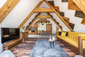 ein Wohnzimmer mit einem Sofa und einem TV in der Unterkunft Apartamenty Polana pod Nosalem - zachód in Zakopane