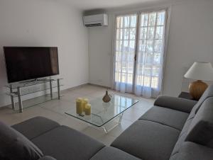a living room with a couch and a tv at Appartement Villa Belle Epoque Roquebrune Cap Martin in Roquebrune-Cap-Martin