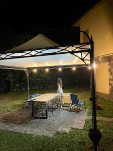a woman sitting at a table under a tent at night at Garden house in Bolsena