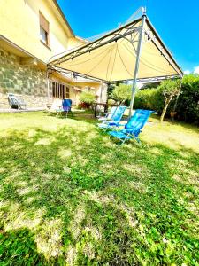 two blue chairs under an umbrella in a yard at Garden house in Bolsena
