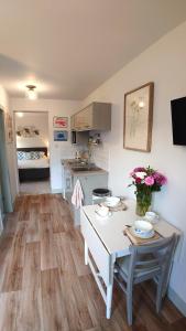 a kitchen and living room with a table with flowers on it at Avocet Lodge, Snettisham in King's Lynn