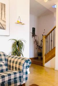 a living room with a plaid couch and a staircase at Boxhill 短租房 in Box Hill