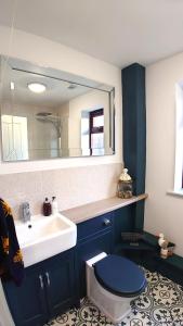 La salle de bains est pourvue d'un lavabo, de toilettes et d'un miroir. dans l'établissement Avocet Lodge, Snettisham, à King's Lynn