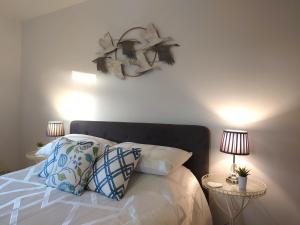 1 dormitorio con 1 cama con almohadas y 2 lámparas en Avocet Lodge, Snettisham en Kings Lynn