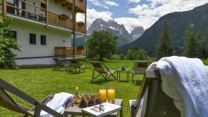 a patio with chairs and a table in the grass at Im Wiesengrund Apartments in Sesto