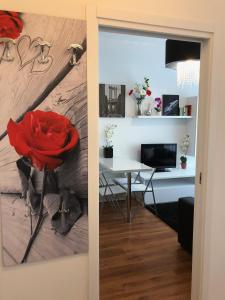 een kamer met een bureau en een rode roos aan de muur bij Your best apartment in Abano Terme in Abano Terme