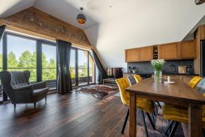 a kitchen and living room with a table and chairs at Apartamenty Polana pod Nosalem - zachód in Zakopane