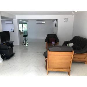 a living room with two couches and a tv at Cha-am Beach Vacation Home in Cha Am