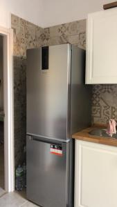 een roestvrijstalen koelkast in de hoek van een keuken bij Virgy’s House in Sestu