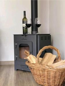 a microwave with two glasses of wine and a basket at Casa 21, aconchegante com lareira in Bento Gonçalves