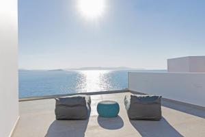 a balcony with two chairs and a view of the ocean at Tholaria Villa in Chania Town