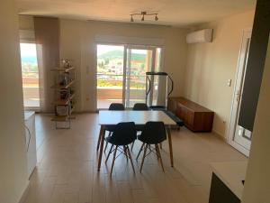 a table and chairs in a room with a large window at Breathtaking sea view in Kavála