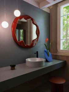 a bathroom with a sink and a mirror on a counter at LABottega - Camere in Marina di Pietrasanta