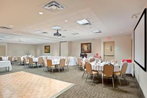 a conference room with tables and chairs and a podium at Holiday Inn Hotel & Suites Surrey East - Cloverdale, an IHG Hotel in Surrey