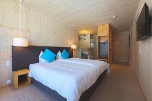 a bedroom with a large white bed with blue pillows at Bever Lodge in Bever