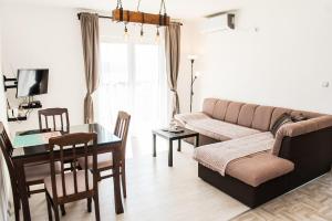 uma sala de estar com um sofá e uma mesa em Apartment Adriatic Blue em Tivat
