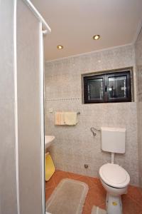 a bathroom with a toilet and a sink at Family friendly apartments with a swimming pool Mundanije, Rab - 5076 in Rab