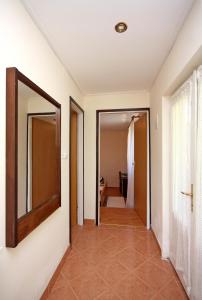 einen Flur mit einem Spiegel an der Wand in der Unterkunft Family friendly apartments with a swimming pool Mundanije, Rab - 5076 in Rab