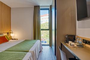 um quarto de hotel com uma cama e uma janela em DWO Colours Alcalá em Madrid