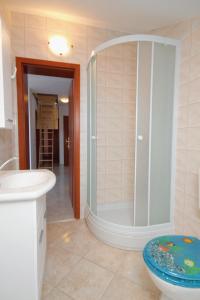 a bathroom with a shower and a toilet and a sink at Apartment Njivice 5458c in Njivice