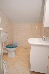 a bathroom with a toilet and a sink at Apartment Njivice 5458c in Njivice