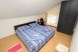 a bedroom with a bed and a woman sitting at a desk at Double Room Njivice 5458a in Njivice