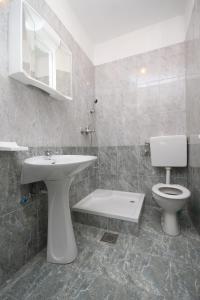 a bathroom with a sink and a toilet and a mirror at Apartments and rooms with parking space Metajna, Pag - 4120 in Metajna
