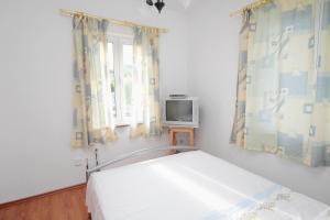 sypialnia z łóżkiem i telewizorem w pokoju w obiekcie Apartment Njivice 5458d w mieście Nijvice