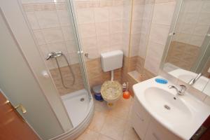 a bathroom with a shower and a toilet and a sink at Apartment Njivice 5458d in Njivice