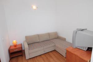 Cette petite chambre dispose d'un canapé et d'une télévision. dans l'établissement Apartment Njivice 5458b, à Njivice