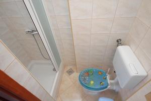La petite salle de bains est pourvue d'une douche et de toilettes. dans l'établissement Apartment Njivice 5458b, à Njivice