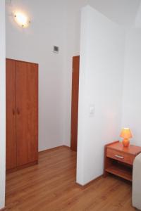 - un salon avec des murs blancs et une table en bois dans l'établissement Apartment Njivice 5458b, à Njivice