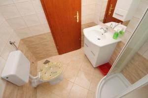 a small bathroom with a toilet and a sink at Apartment Njivice 5458f in Njivice +16 photos
