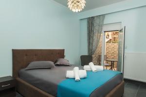 sypialnia z niebieskim łóżkiem i ręcznikami na nim w obiekcie Dream Apartment "self check in" w Salonikach
