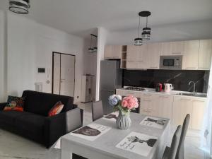 un soggiorno con divano e tavolo con fiori di DREAM HOUSE a Lido di Ostia