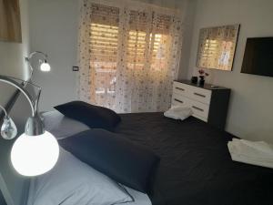 a bedroom with a bed with blue pillows and a dresser at DREAM HOUSE in Lido di Ostia