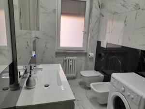 La salle de bains blanche est pourvue d'un lavabo et d'un lave-linge. dans l'établissement DREAM HOUSE, à Lido di Ostia