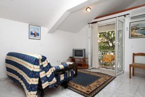 ein Wohnzimmer mit einem Sofa und einem TV in der Unterkunft Apartments by the sea Drvenik Donja vala, Makarska - 6658 in Drvenik