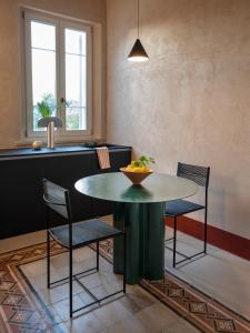 a kitchen with a table with chairs and a bowl of fruit on it at LABottega - Camere in Marina di Pietrasanta