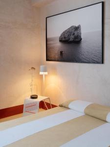 a bedroom with two beds and a tv on the wall at LABottega - Camere in Marina di Pietrasanta