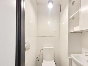Baño blanco con aseo y lavamanos en Pomorska Rooms en Lodz