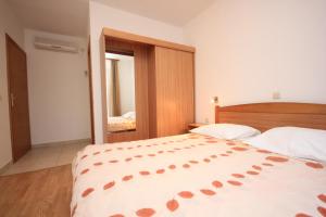 ein Schlafzimmer mit einem großen Bett und einem Spiegel in der Unterkunft Double Room Zaglav 8144a in Zaglav
