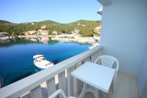 a balcony with a table and a boat in the water at Double Room Zaglav 8144a in Zaglav