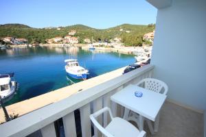 einen Balkon mit einem Tisch und einem Boot im Wasser in der Unterkunft Double Room Zaglav 8144b in Zaglav