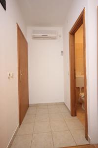 a hallway with a bathroom with a toilet and a heater at Double Room Zaglav 8144a in Zaglav