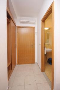 a hallway with a wooden door and a bathroom at Double Room Zaglav 8144c in Zaglav